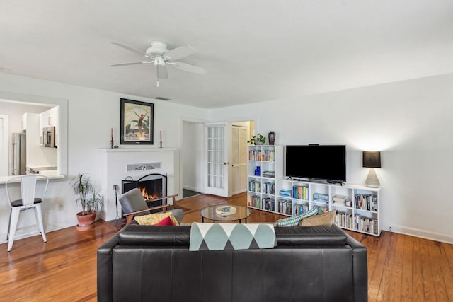 living room featuring hardwood / wood-style floors and ceiling fan