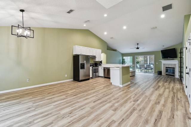 kitchen featuring visible vents, a tiled fireplace, appliances with stainless steel finishes, open floor plan, and light countertops