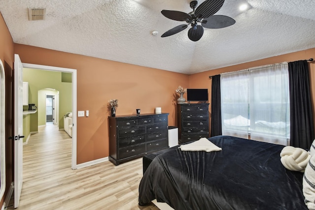 bedroom featuring ceiling fan, a textured ceiling, and light wood-type flooring