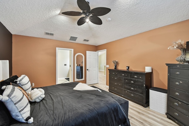 bedroom with light wood-type flooring, visible vents, and a textured ceiling