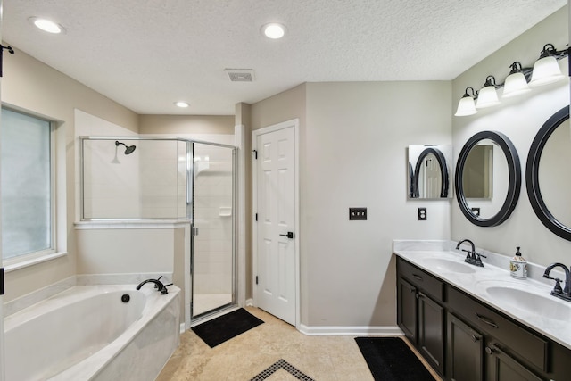 bathroom with vanity, tile patterned flooring, a textured ceiling, and plus walk in shower