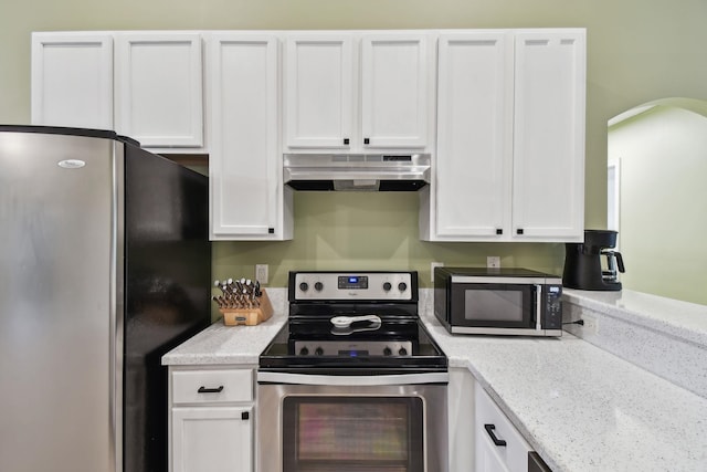 kitchen with appliances with stainless steel finishes, white cabinets, and under cabinet range hood