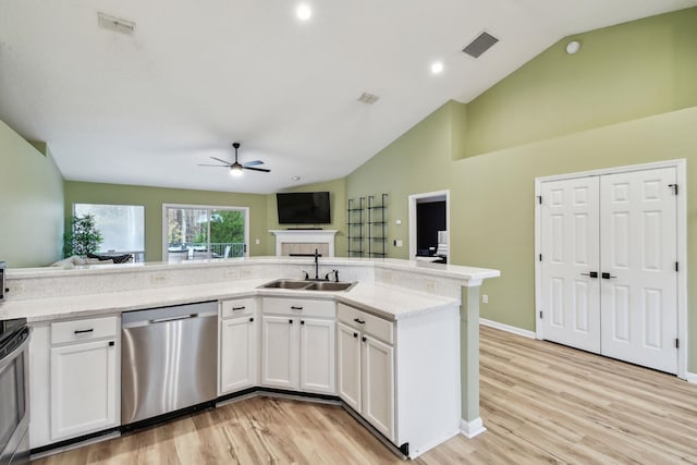 kitchen featuring stainless steel appliances, visible vents, open floor plan, white cabinetry, and a sink