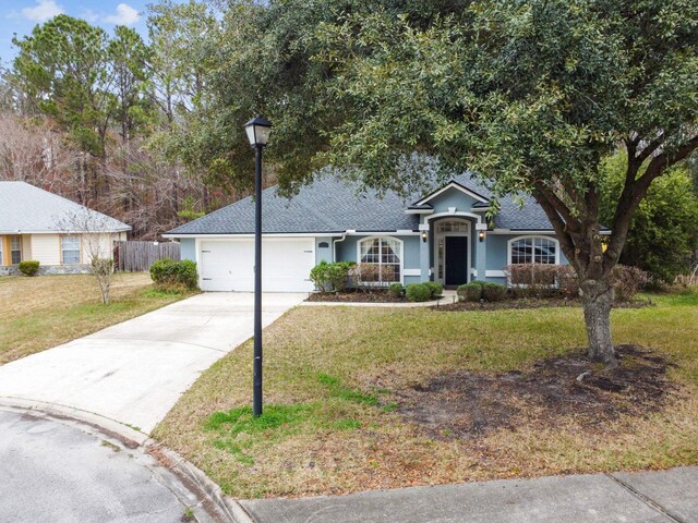 ranch-style home with a garage and a front yard