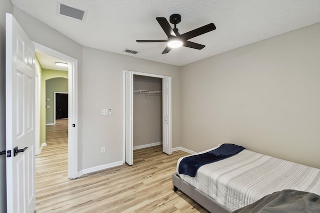 bedroom featuring ceiling fan, a closet, and light wood-type flooring