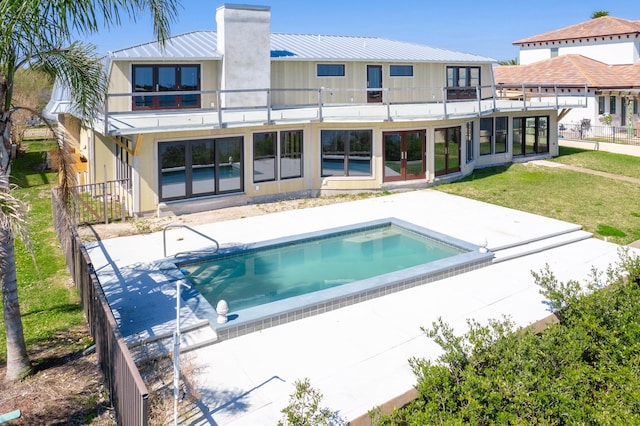 back of property with a yard, a balcony, and a patio area