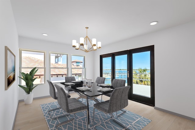 dining space featuring an inviting chandelier and light wood-type flooring