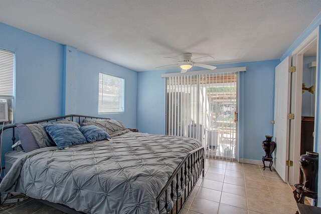 bedroom with ceiling fan, light tile patterned flooring, access to exterior, and a textured ceiling