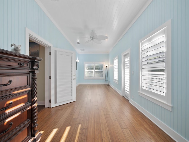 hallway with light wood-type flooring and crown molding