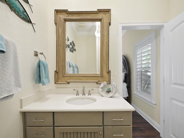 bathroom with crown molding, vanity, and hardwood / wood-style flooring