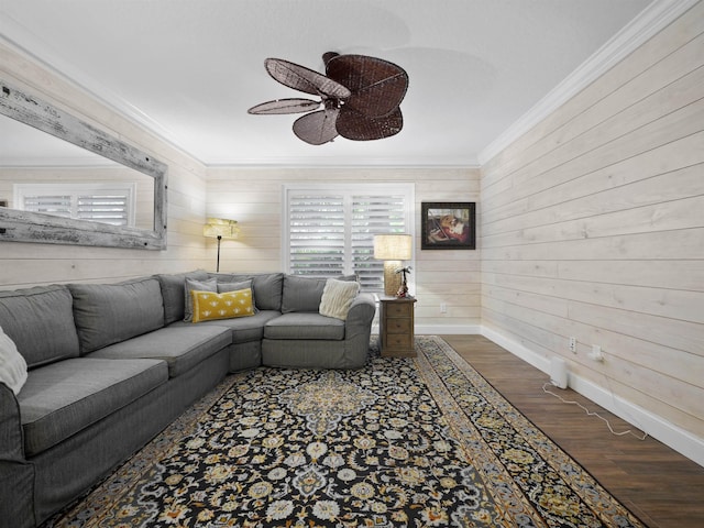 living room with wood-type flooring, wooden walls, ceiling fan, and ornamental molding