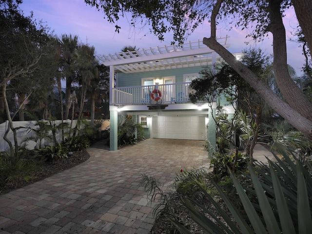 patio terrace at dusk featuring a garage