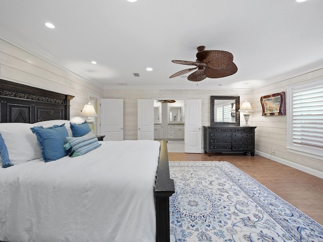 bedroom with hardwood / wood-style floors, wooden walls, ceiling fan, and ornamental molding