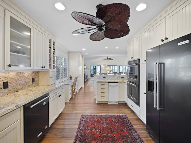 kitchen featuring plenty of natural light, lofted ceiling, stainless steel appliances, and dark wood-type flooring