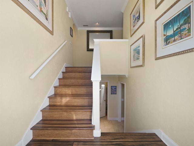 stairs with hardwood / wood-style flooring and ornamental molding