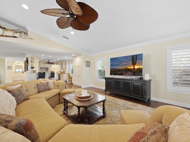 living room with ceiling fan, lofted ceiling, crown molding, and dark wood-type flooring