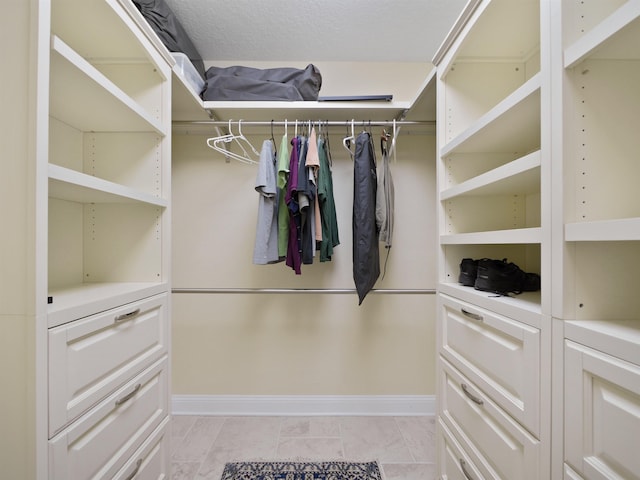 walk in closet with light tile patterned floors