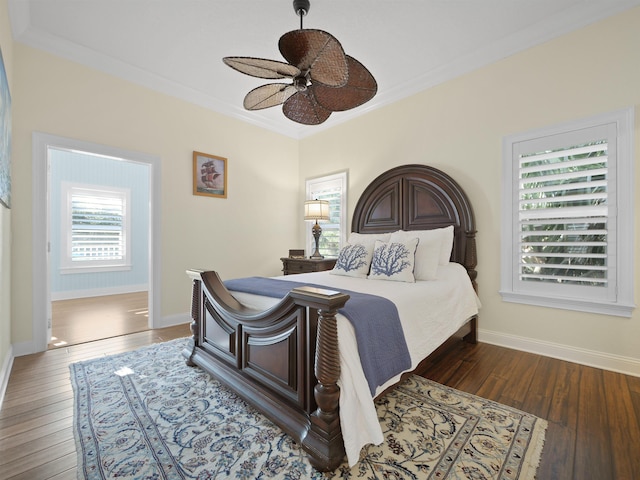 bedroom featuring ceiling fan, crown molding, and dark wood-type flooring