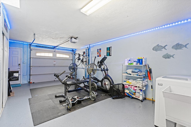 exercise room featuring a textured ceiling, sink, and washer / clothes dryer