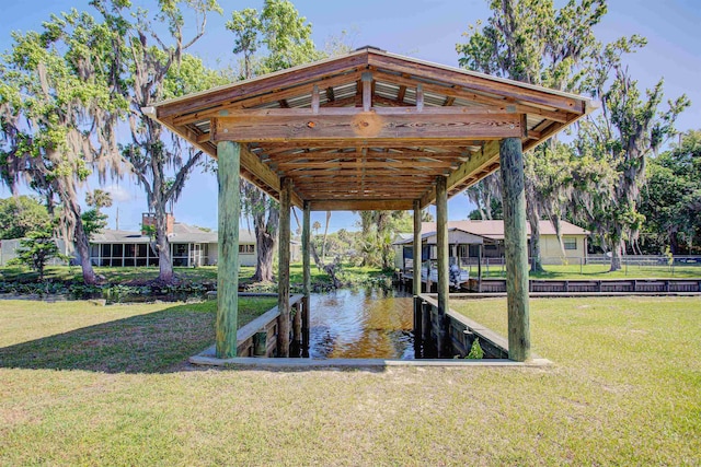 view of dock with fence, a water view, and a yard