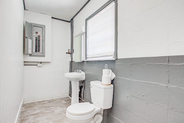 half bathroom featuring electric panel, baseboards, a sink, and toilet
