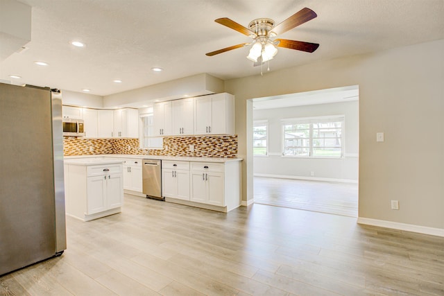 kitchen with tasteful backsplash, light wood-type flooring, a ceiling fan, light countertops, and appliances with stainless steel finishes