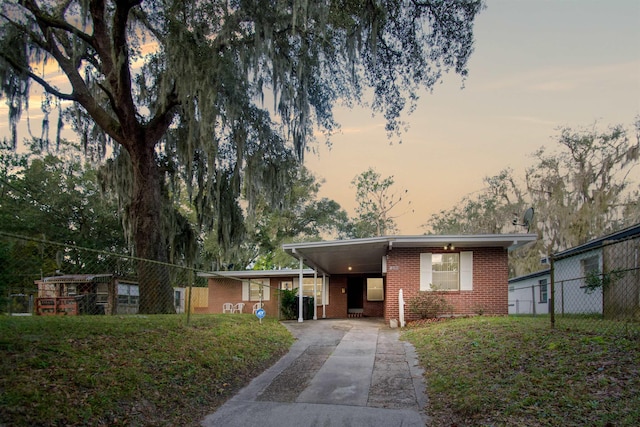 100 Spring St, Saint Augustine, FL 32084 - view of front facade featuring brick siding, driveway, and a carport
