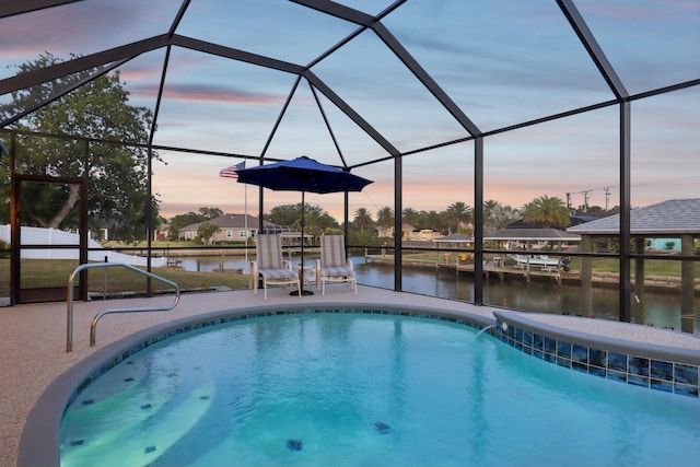 pool at dusk featuring a water view, a patio, glass enclosure, and an outdoor pool