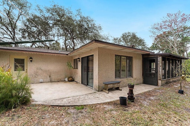 rear view of house with a patio and a sunroom