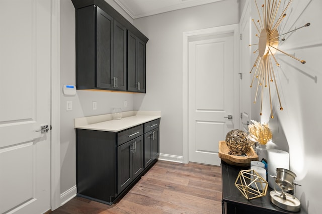 87 Amarante Ln, Saint Augustine, FL 32095 - laundry area with light wood-style floors, baseboards, crown molding, and a chandelier