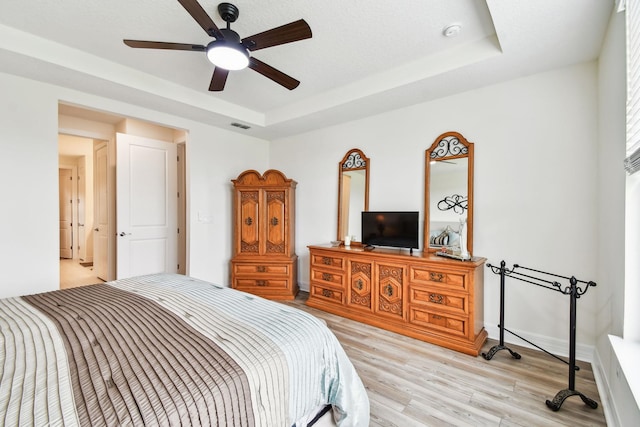 82 Lone Cypress Way, Saint Augustine, FL 32092 - bedroom featuring light wood-style floors, a tray ceiling, and ceiling fan