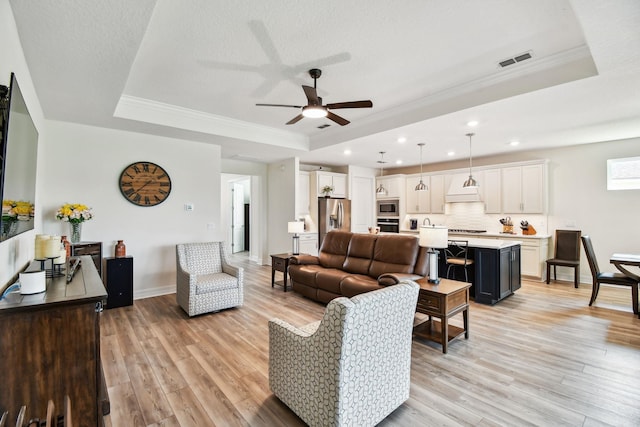 82 Lone Cypress Way, Saint Augustine, FL 32092 - living area featuring a raised ceiling, a ceiling fan, light wood-style floors, ornamental molding, and recessed lighting