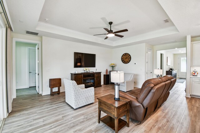 82 Lone Cypress Way, Saint Augustine, FL 32092 - living room featuring a raised ceiling, light wood-type flooring, ceiling fan, and ornamental molding