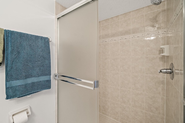 bathroom featuring a shower stall and a textured ceiling