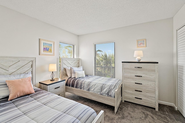 carpeted bedroom featuring baseboards and a textured ceiling