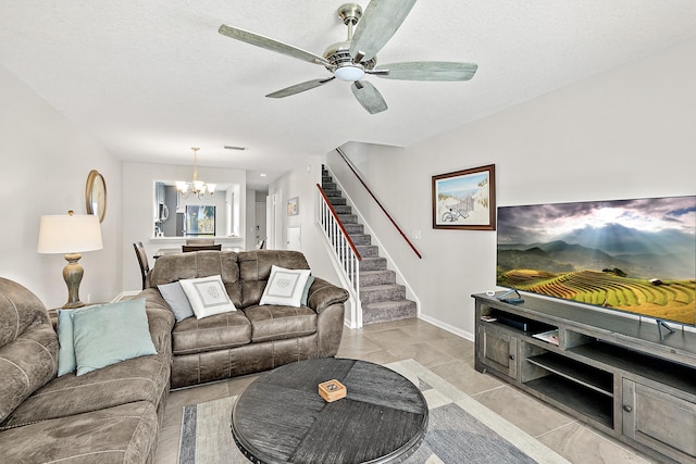 living area with baseboards, stairs, light tile patterned floors, ceiling fan with notable chandelier, and a textured ceiling