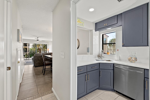 kitchen with a sink, dishwasher, light tile patterned flooring, and light countertops