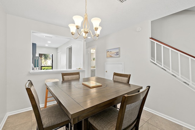 dining space with light tile patterned flooring, an inviting chandelier, and baseboards