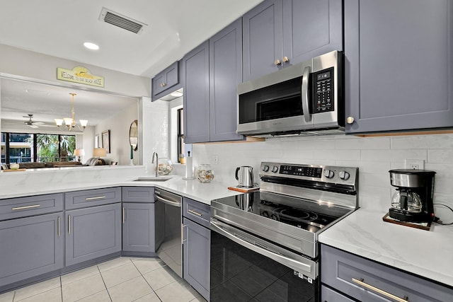 kitchen featuring visible vents, gray cabinets, a sink, appliances with stainless steel finishes, and tasteful backsplash