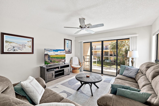 living room with a ceiling fan and a textured ceiling