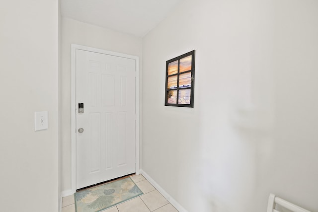 doorway with light tile patterned floors and baseboards