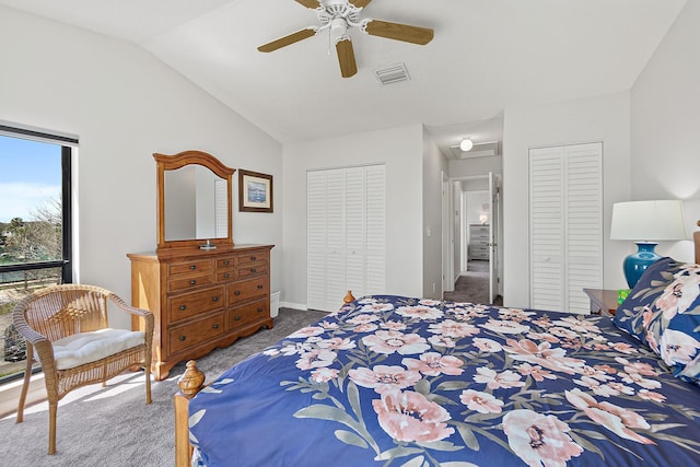 carpeted bedroom featuring visible vents, ceiling fan, lofted ceiling, and multiple closets