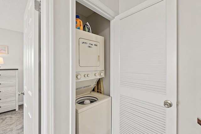 laundry area with stacked washer / dryer, carpet flooring, and laundry area