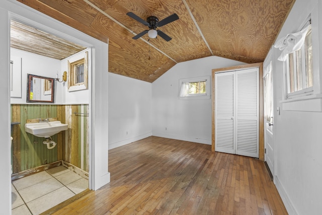 bonus room with wooden walls, ceiling fan, wood ceiling, and wood-type flooring