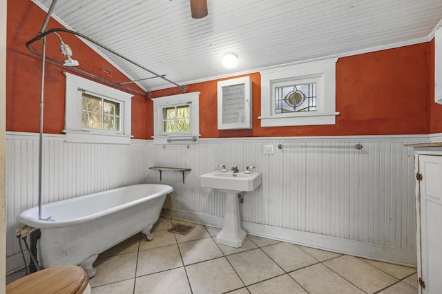 bathroom with tile patterned floors, ceiling fan, lofted ceiling, and a bath