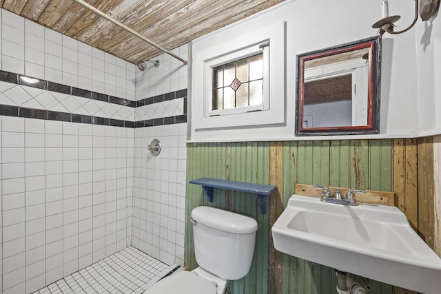 bathroom featuring tiled shower, sink, toilet, and wood ceiling