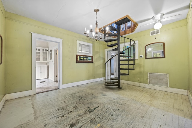 entryway with ceiling fan with notable chandelier