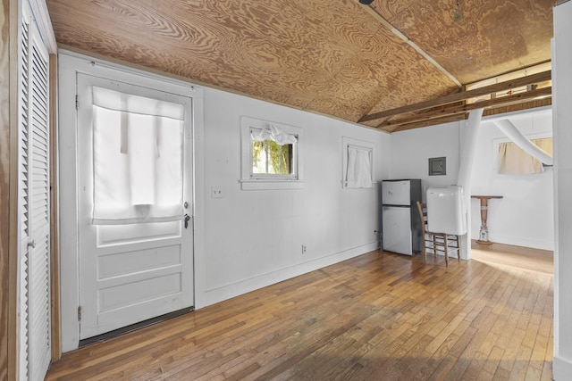 entryway featuring hardwood / wood-style flooring, electric panel, and vaulted ceiling