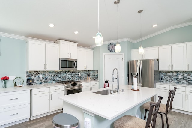 kitchen with white cabinetry, sink, an island with sink, decorative light fixtures, and appliances with stainless steel finishes