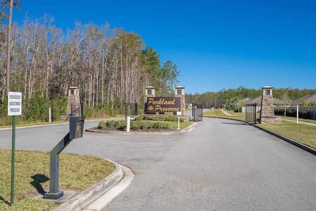 view of road with curbs and a gated entry